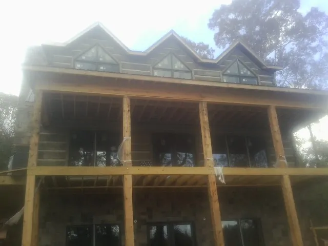 Dormers and porch framing on a large log home under construction — Roof Coating work by our crew in Hiko